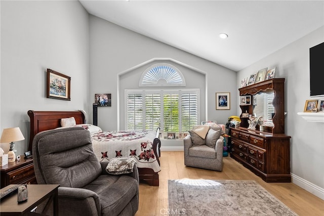 bedroom featuring lofted ceiling, light wood finished floors, and baseboards