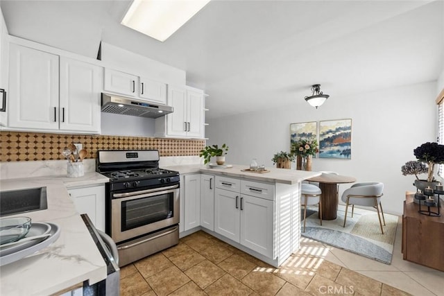 20234 Cohasset St Unit 11, Winnetka, CA 91306 - kitchen featuring stainless steel gas stove, under cabinet range hood, a peninsula, backsplash, and white cabinetry