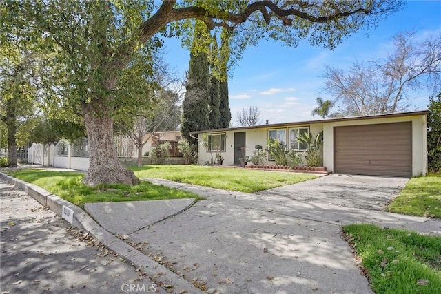 ranch-style home featuring a garage, fence, driveway, stucco siding, and a front yard