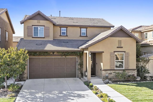 view of front of property with a garage, concrete driveway, stone siding, a tile roof, and stucco siding