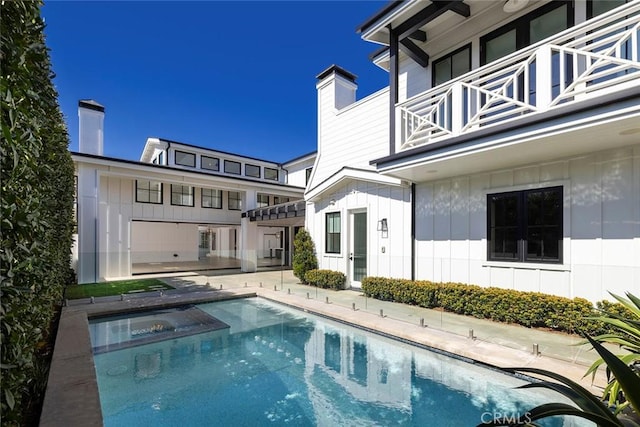 view of swimming pool with a patio area and a pool with connected hot tub