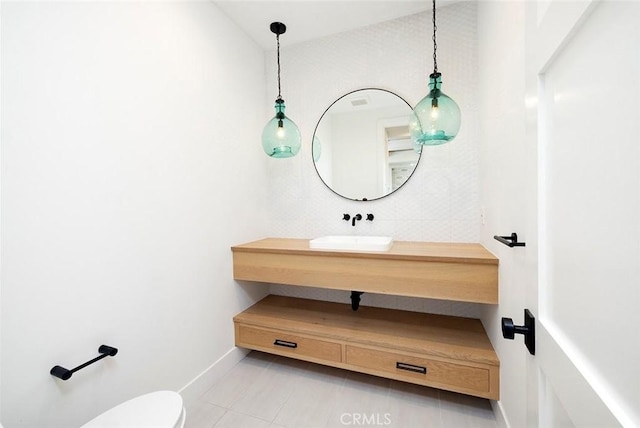 bathroom with toilet, tile patterned flooring, baseboards, and vanity