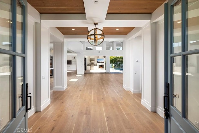 entryway with recessed lighting, light wood-style floors, wood ceiling, a chandelier, and baseboards