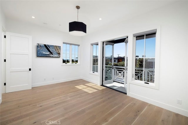 empty room with recessed lighting, light wood-style flooring, and baseboards