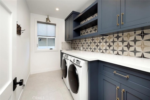 laundry room featuring washing machine and clothes dryer, recessed lighting, cabinet space, a sink, and baseboards