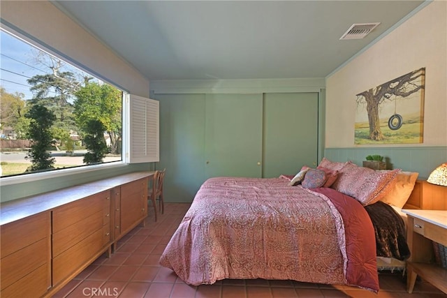 tiled bedroom featuring a closet and visible vents