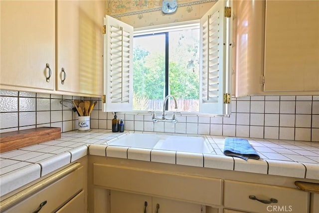 kitchen with tasteful backsplash, a sink, and tile countertops