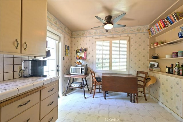 interior space featuring wallpapered walls, ceiling fan, and light floors