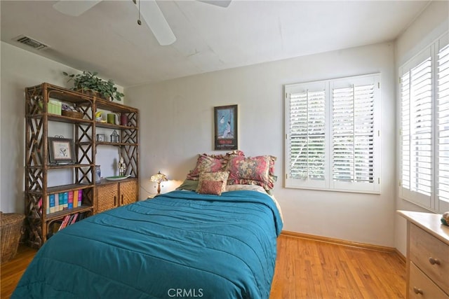 bedroom with visible vents, ceiling fan, baseboards, and wood finished floors