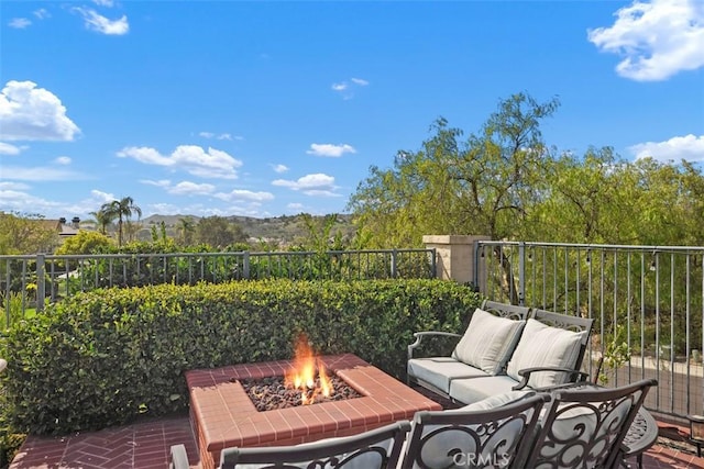 view of patio / terrace featuring an outdoor living space with a fire pit and fence