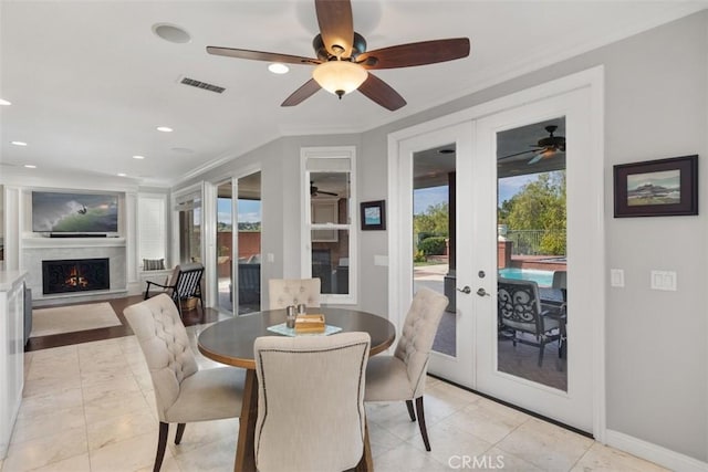 dining space featuring french doors, crown molding, visible vents, a premium fireplace, and baseboards