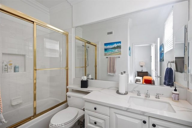 full bathroom with visible vents, toilet, shower / bath combination with glass door, crown molding, and vanity