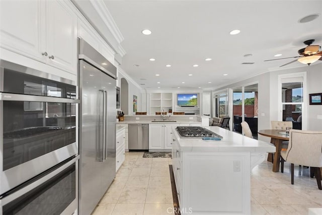 kitchen with stainless steel appliances, a kitchen island, a sink, and light countertops