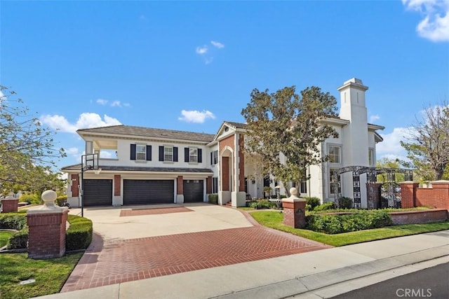 view of front of home with a garage, decorative driveway, and stucco siding