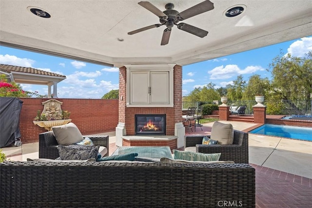 view of patio featuring ceiling fan, an outdoor living space with a fireplace, a fenced backyard, and a fenced in pool