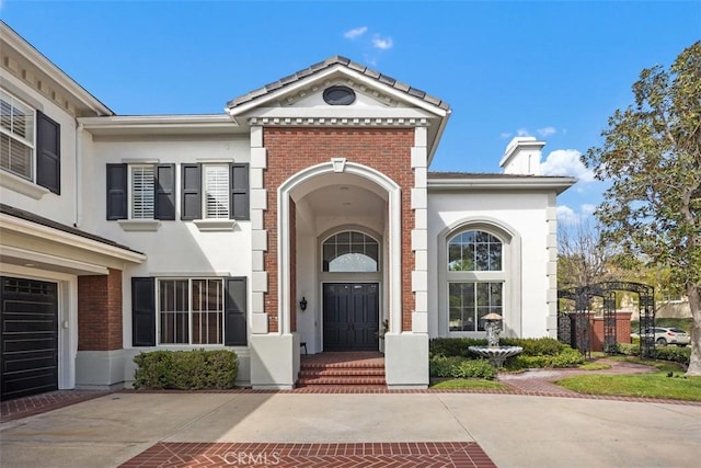 doorway to property with brick siding, a chimney, and stucco siding