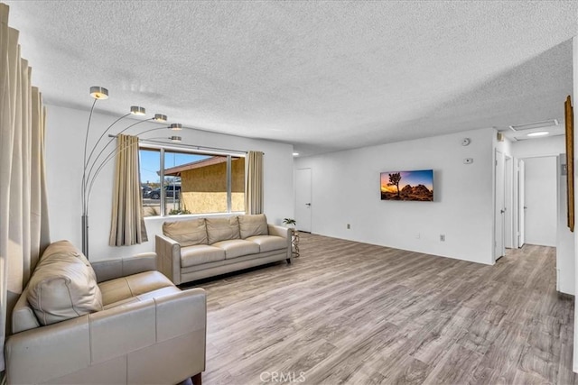 living area featuring a textured ceiling and wood finished floors