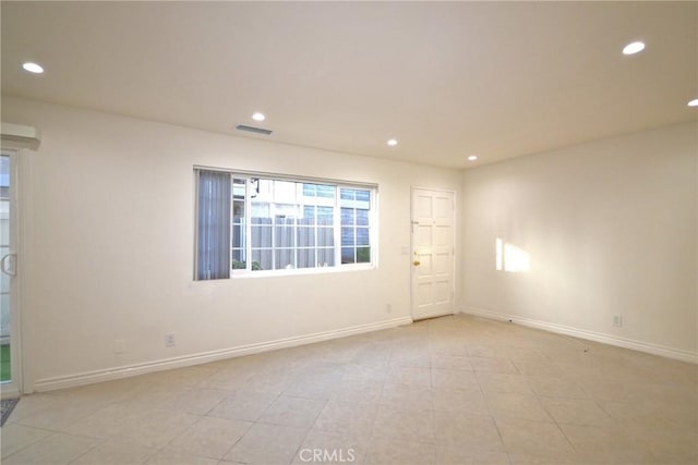 unfurnished room featuring baseboards, visible vents, and recessed lighting