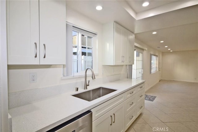 kitchen with stainless steel dishwasher, a sink, white cabinetry, and recessed lighting