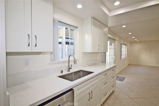 kitchen with a sink, light countertops, recessed lighting, and white cabinets