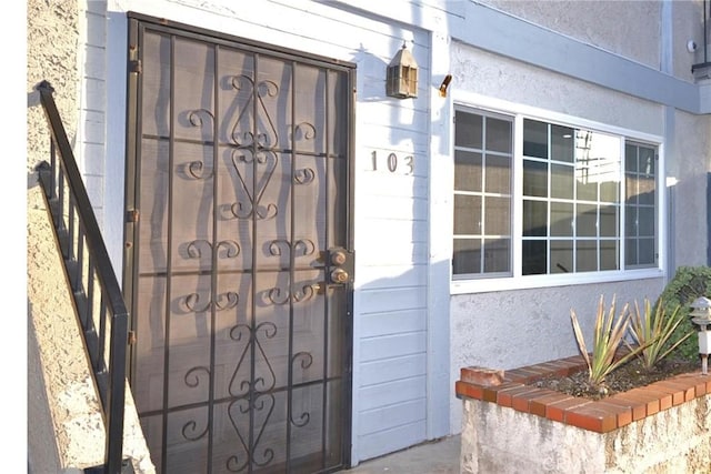 entrance to property featuring stucco siding