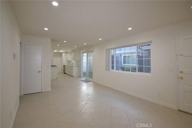 empty room featuring recessed lighting, baseboards, and light tile patterned floors