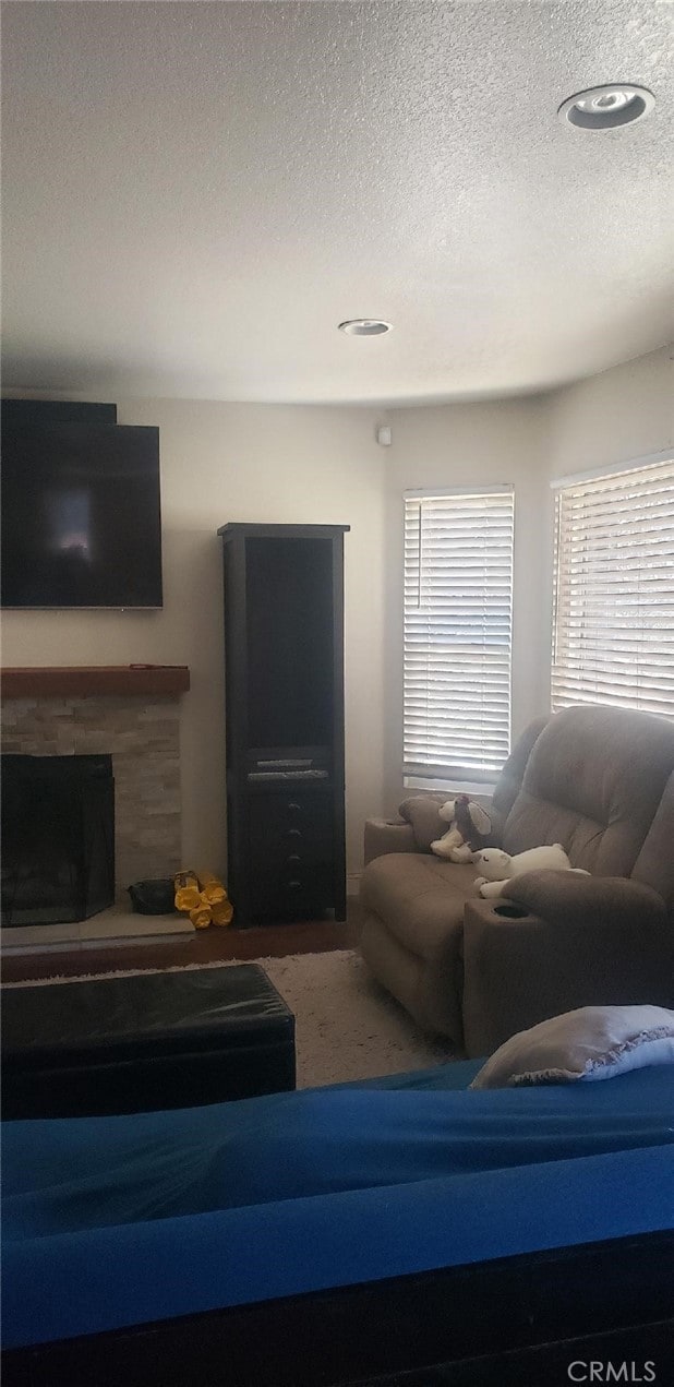 living room with a fireplace and a textured ceiling