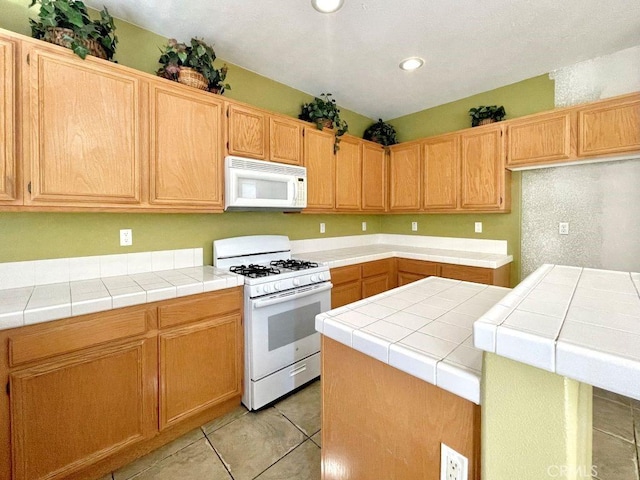 kitchen featuring white appliances, recessed lighting, tile counters, and light tile patterned flooring