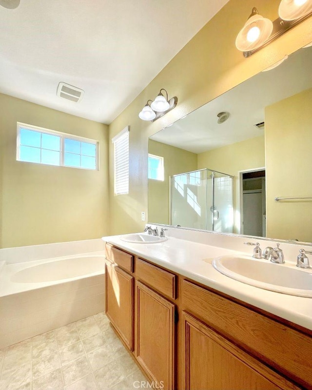 full bathroom featuring double vanity, a sink, a shower stall, and a bath