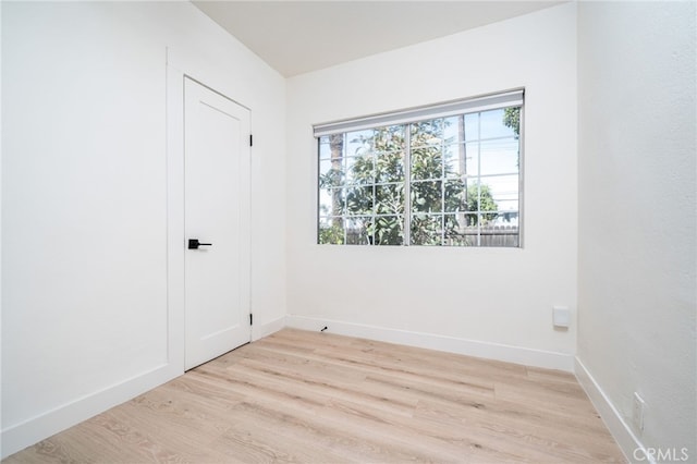 unfurnished room featuring light wood-type flooring and baseboards