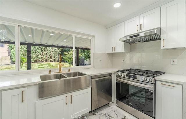 kitchen featuring marble finish floor, stainless steel appliances, white cabinets, a sink, and under cabinet range hood