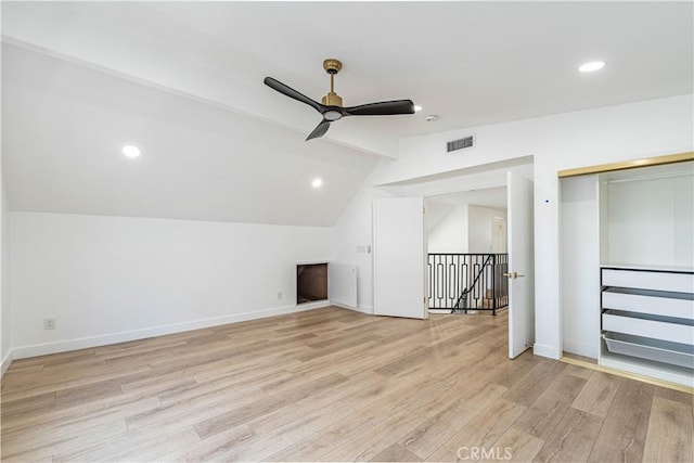 additional living space with baseboards, visible vents, a ceiling fan, lofted ceiling with beams, and light wood-type flooring