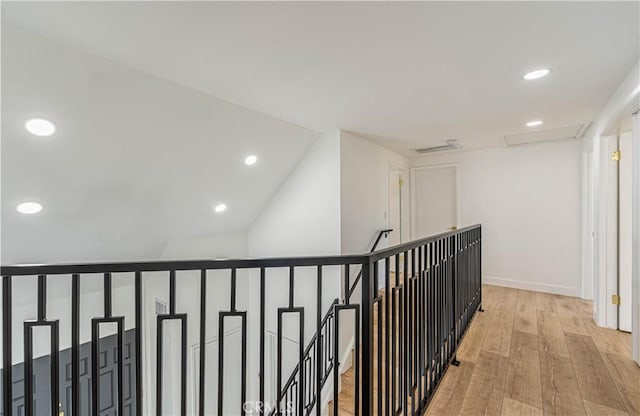 corridor with recessed lighting, visible vents, attic access, light wood-type flooring, and baseboards