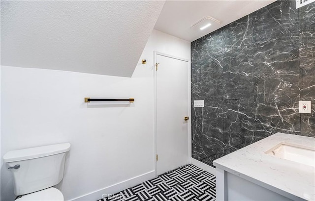 bathroom with toilet, a textured ceiling, and vanity