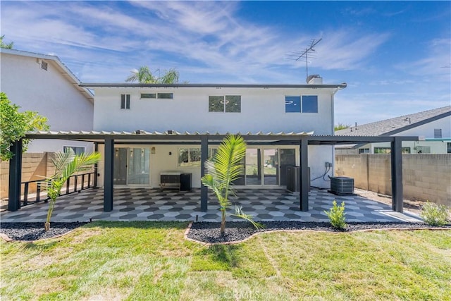 back of property with a patio, a yard, fence, and stucco siding