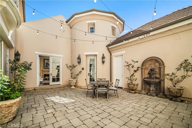 back of property with stucco siding, outdoor dining area, and a patio