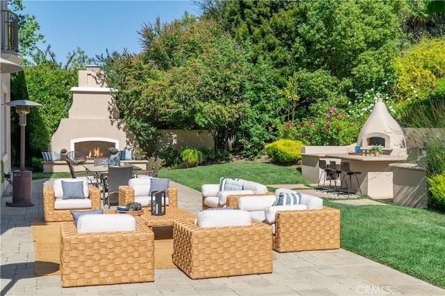 view of patio with an outdoor living space with a fireplace, outdoor dry bar, and outdoor dining space