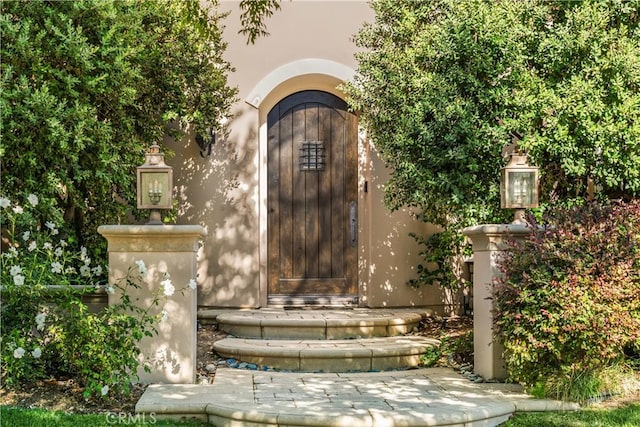 view of exterior entry featuring stucco siding