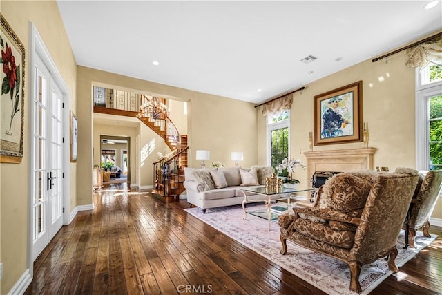 living area with dark wood-style floors, stairway, a fireplace, and visible vents