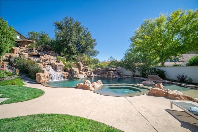 view of pool featuring fence and an in ground hot tub