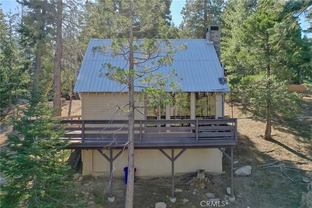612 Rose Ln, Twin Peaks, CA 92391 - back of house featuring a chimney, metal roof, and a wooden deck