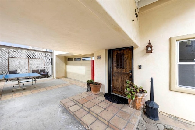 property entrance featuring a patio and stucco siding