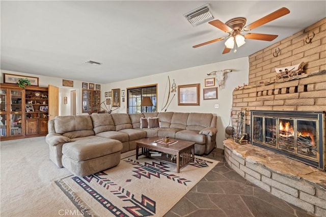 living area featuring visible vents, a fireplace, carpet flooring, and ceiling fan