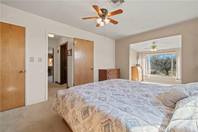 bedroom with a ceiling fan, visible vents, light carpet, and baseboards