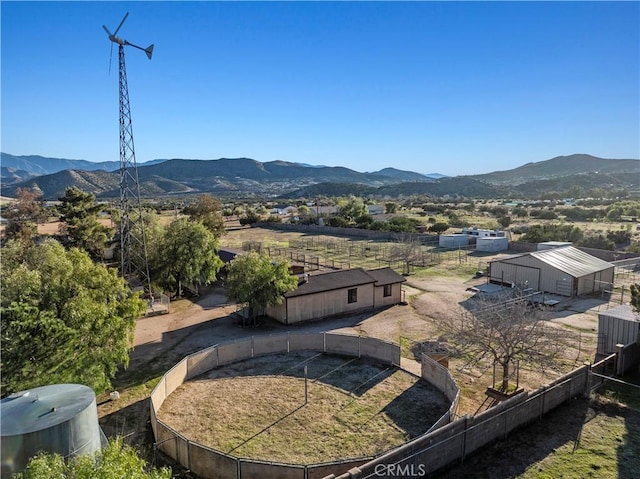 view of property's community with an outdoor structure, fence, and a mountain view