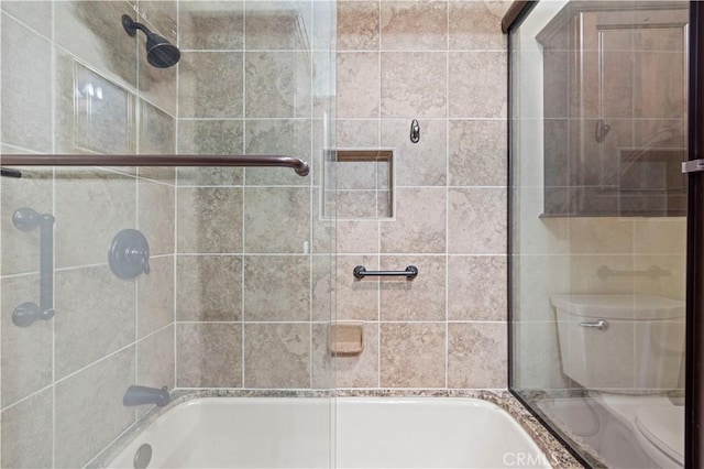 bathroom featuring toilet and shower / bath combination with glass door