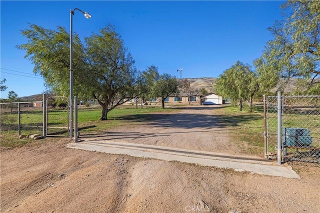 view of street featuring driveway, a gate, and a gated entry