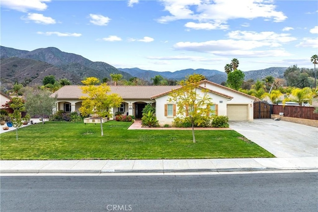 view of front of house featuring a mountain view, a garage, fence, concrete driveway, and a front lawn