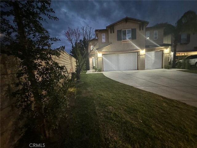 view of front of home featuring a garage, fence, driveway, a lawn, and stucco siding