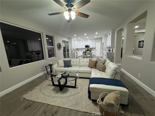 living area with ceiling fan, baseboards, wood finished floors, and recessed lighting